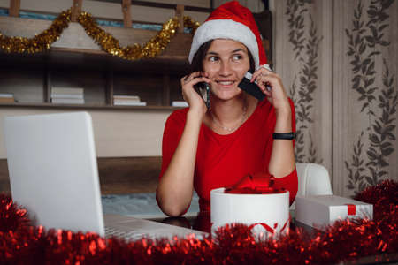 christmas, technology, people and online shopping concept. asian woman in santa helper hat with gift box, laptop computer and credit card over holidays lights backgroundの写真素材