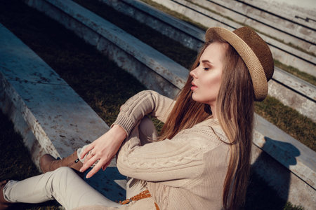 A young gorgeous woman on a walk through the sunny winter park. Near the stadium in Krasnodar,...