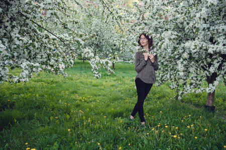 A young pregnant woman in an apple orchard in the heart of Warsaw. Relaxing in the spring in Polandの写真素材