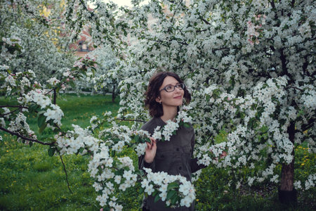 A young pregnant woman in an apple orchard in the heart of Warsaw. Relaxing in the spring in Polandの写真素材