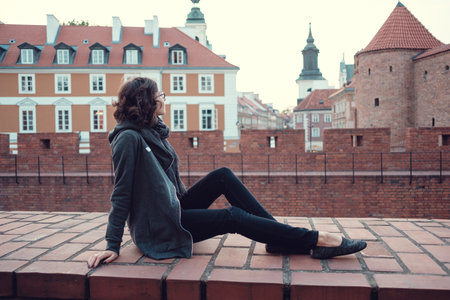 Outdoor portrait of young beautiful lady posing on old street. Evening old Warsaw, Poland, springの写真素材