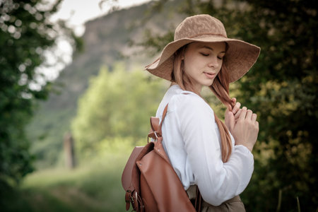 woman traveler with backpack and hat walking in amazing mountains and forest, wanderlust travel concept, space for text, atmospheric moment. earth dayの写真素材