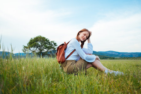 woman traveler with backpack and hat walking, wanderlust travel concept, space for text, atmospheric moment. earth dayの写真素材