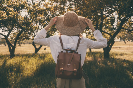 woman traveler with backpack and hat walking in amazing forest, wanderlust travel concept, space for text, atmospheric moment. earth dayの写真素材
