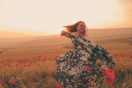 Young beautiful woman in spring field. concept of freedom. walking in amazing poppy field. Warm...