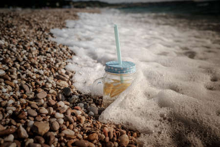 mojito on summer sandy beach. Mojito in glass jars on the sea coast. summer beach fun in the seaの写真素材