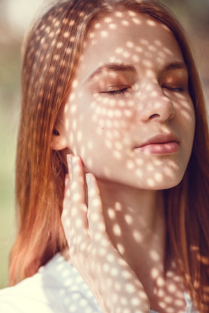 Portrait of a charming young woman outdoor. Light and shadow. interesting portrait of young girl's...