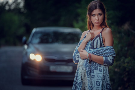 Pretty young woman hitchhiking along a road. Portrait of a beautiful young Asia woman. Image is...
