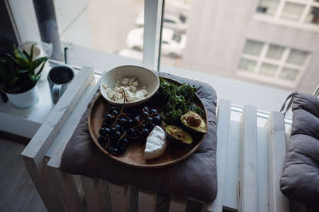 Hygge concept, autumn mood. Relaxing in cold weather. vegetarian breacfast: avocado, cheese and grapesの写真素材