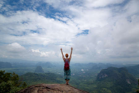 Girl enjoys a beautiful view of the valley and the Andaman Sea, islands and mountains from the viewpoint, Krabi, Thailandの写真素材
