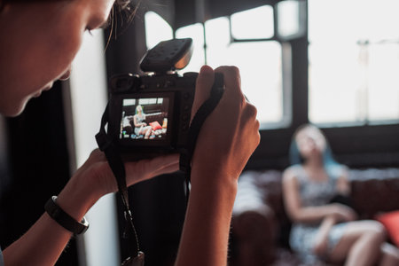 Close-up of hand holding camera. Mirrorless camera close up in the hand of a young man on a studio...
