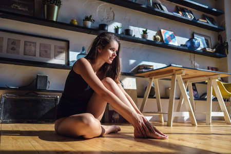 Model with perfect sensual figure pose in home interior. Sexy lady in classic room with sunny light. The concept and idea of a happy awakening, good morning and comfort at home.の写真素材