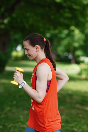 Sport training concept. The girl is engaged in fitness in nature. Side view of young woman doing...