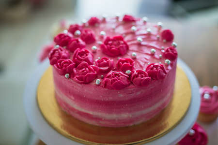 Beautiful pink cream and berries cake on a light concrete background. Birthday celebrationの写真素材