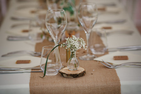 Outdoor catering dinner at the wedding with homemade garnishes decoration. Rustic and boho style...