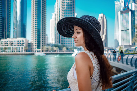 Happy young traveler woman in big city Dubai. Luxury travel vacation. Woman looking at view. Dubai...