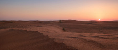 Sunset over the sand dunes in the desert. The ghost town of Al-Madam is about 60 km from Dubai City. united arab emirates. The concept of global warmingの写真素材