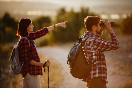 Portrait of happy young couple having fun on their hiking trip. Caucasian and asian hiker couple...