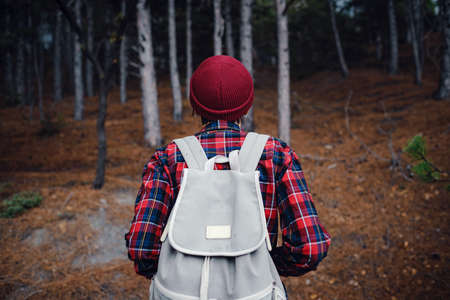 A woman hiker with a backpack enjoying a view of the mountains in the fog. Traveling in the mountains, freedom and an active lifestyleの写真素材