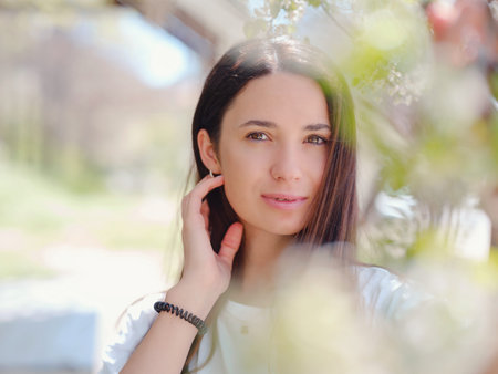 Young smiling brunette woman outdoors portrait. sunny spring or summer day in nature
