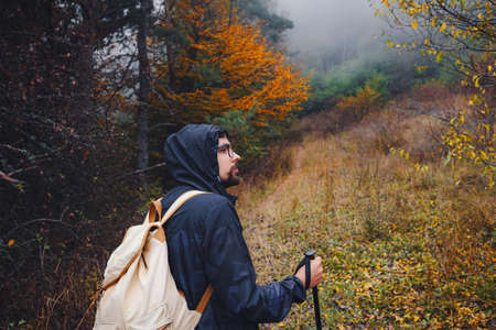 young man traveler in autumn misty nature. rear view. concept active healthy lifestyle, adventure and travel vacationの写真素材