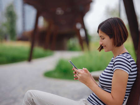 beautiful young asian woman spending time in contemporary city park on summer day.の写真素材