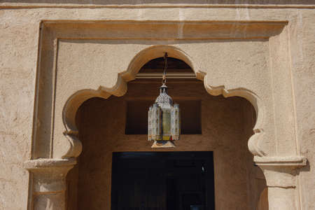 Traditional Arabic metal streetlight over wooden door. Al Seef Clay Houses. Deira, BurDubaiの写真素材