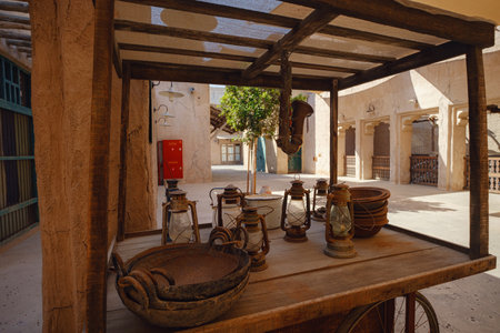 Dubai, UAE 17 February 2020: Old Dubai buildings and Arabian street. Historical Al Fahidi neighborhood, Al Bastakiya. Heritage district in United Arab Emirates. cart with old arabic brass wareのeditorial素材