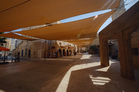 Dubai, UAE 17 February 2020: Old Dubai buildings and Arabian street. Historical Al Fahidi neighborhood, Al Bastakiya. Heritage district in United Arab Emirates. cool shadow on city streets at noonのeditorial素材