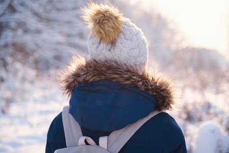 Happy Asian woman walking in winter snow forest. Cold weather hat and warm coat. idea and concept of healthy active lifestyle and good mood in any weatherの写真素材