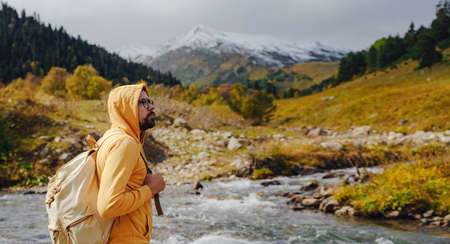 Man hiking mountains with travel backpack. Wandering lifestyle, adventure concept autumn vacation outdoors, alone in the wild. Travel to North Caucasus, Arkhyz, Russia, road to Dukkinsky lakesの写真素材
