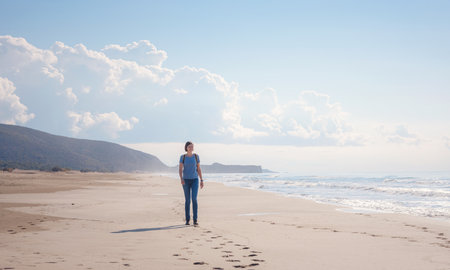 Backpacker female sitting on the Patara sand dunes beach enjoying the windy Mediterranean Sea during Lycian Way trekking walk. Famous Likya Yolu Turkish route. active people vacation concept imageの写真素材