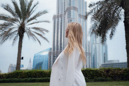 Young beautiful blonde woman enjoying walk in Dubai downtown. Enjoying travel in United Arabian Emirates. Vacation and sightseeing conceptの写真素材