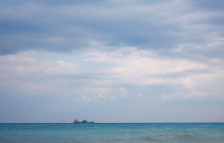 Cargo ship in calm blue Mediterranean in Anatalya. Traveling along the Mediterranean Sea, view of...