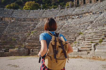 walk in Antalya Turkey on warm October afternoon. Pretty tourist woman with backpack at ruins of ancient city of Pergeの写真素材