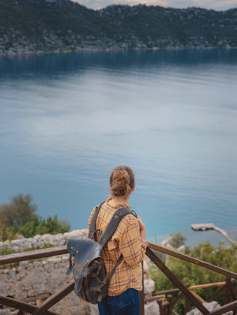 Travel and tourist attractions at Kekova island, Turkey. Woman traveler explores ruins castle of Simena with view of sea bay and Kekova Island with famous flooded city. Tourist attractions in Turkey.の写真素材