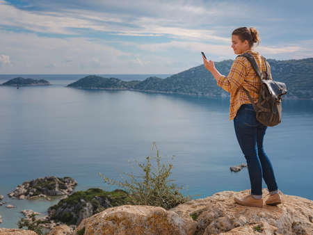 Travel and tourist attractions at Kekova island, Turkey. Woman traveler explores ruins castle of Simena with view of sea bay and Kekova Island with famous flooded city. Tourist attractions in Turkey.の写真素材