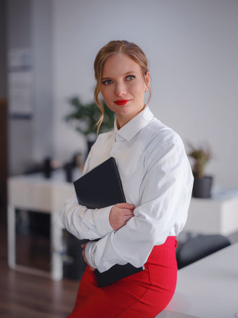 business woman working in office. Online business, young professional in the workplace. Portrait of attractive cheerful lady hr leader director real estate agency broker at work place station indoorsの写真素材