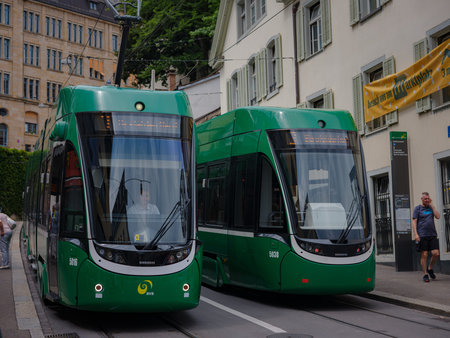 Basel, Switzerland - July 4 2022: public transport in the city. Green tram in street of Basel city...