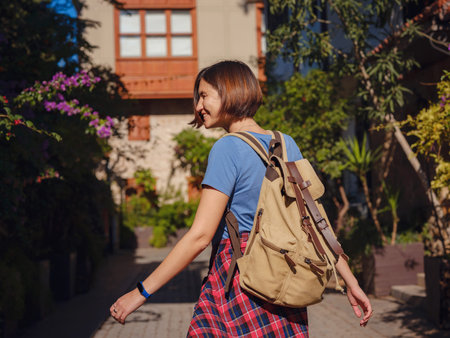 travel to Turkey, old town Antalya Kaleci. Happy asian female tourist traveler with backpack walks in old city. beautiful old street with blooming bougainvillea bushesの写真素材