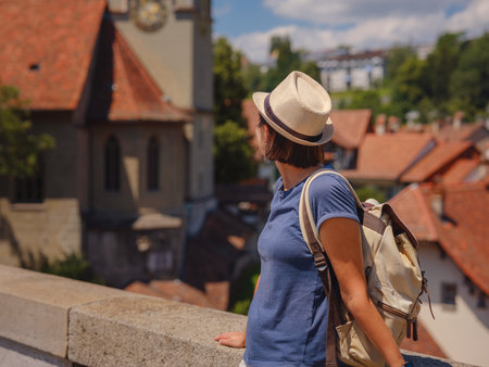 having a great vacation in Switzerland, Bern. Lady tourist attractions visiting and landmarks. Woman tourist on top of cityscape view to old town of Bernの写真素材
