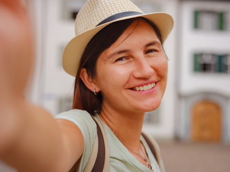 travel to summer europe young asian woman. Woman having a great vacation in Switzerland, Basel. Lady tourist attractions visiting and landmarks. woman taking selfie with smart phoneの写真素材