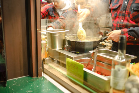 Dusselldorf, Germany - December 13, 2022: Women preparing langosh, a traditional Hungarian rich flatbread fried in oil. food preparation at the festival christmas marketのeditorial素材