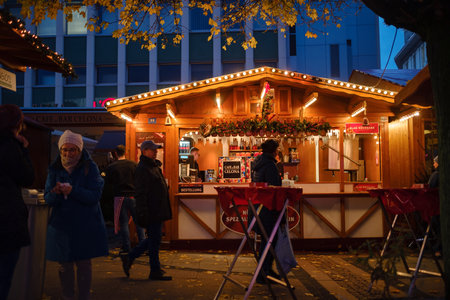Essen. GERMANY. 13 DECEMBER 2022. The Christmas market in Germany. Celebrating Xmas holidays. Lights, carousel, small houses at the market in the city center with amazing food selection.のeditorial素材
