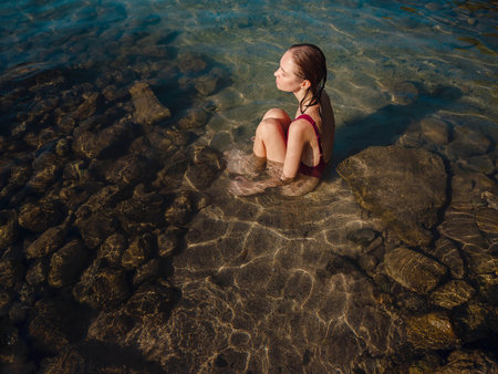 female tourist wearing swimsuit relaxing in sea at beach near ancient city Phaselis, Kemer Antalya province Turkey. ancient port city with beach and ruins of ancient Roman baths, theaters, aqueductsの写真素材