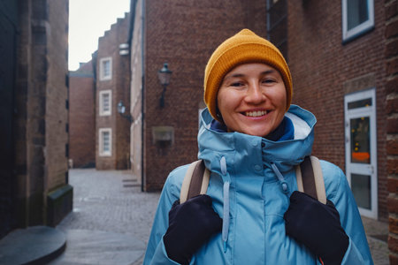 winter travel to Dusseldorf, Germany. young Asian tourist in blue jacket and yellow hat (symbol of...