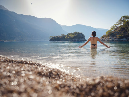 Summer lifestyle portrait of Happy traveler woman in black swimsuit enjoys her tropical beach vacation in Oludeniz Lagoon Turkey.の写真素材