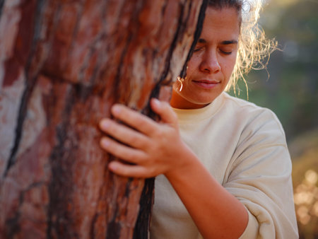 woman love nature hugging pine tree, no deforestation concept and earths day celebration, care for earth, meditation, save our planet for nice and better future - outdoor leisure activityの写真素材