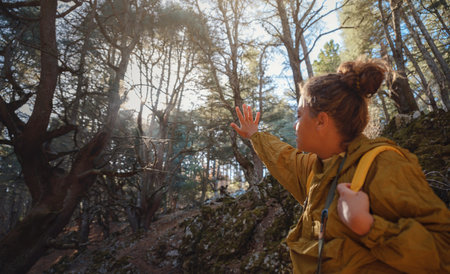 caucasian woman enjoys being in nature, beautiful forest in mountains. embracing fresh air and engaging in outdoor activities. Friluftsliv concept means spending as much time outdoors as possibleの写真素材