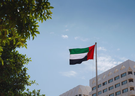 United Arab Emirates flag flying against the sky. UAE celebrates it's national day on 2nd December every year.の写真素材